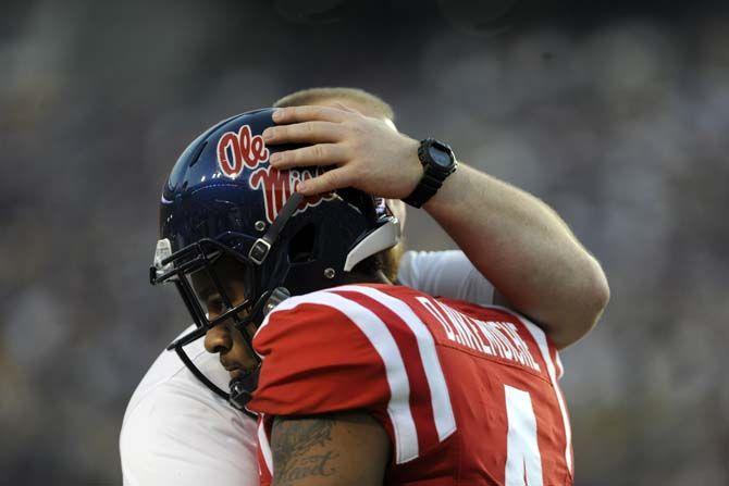 Ole Miss junior linebacker is embraced by a coach after losing 10-7 to LSU in Tiger Stadium on Saturday, October 25, 2014.