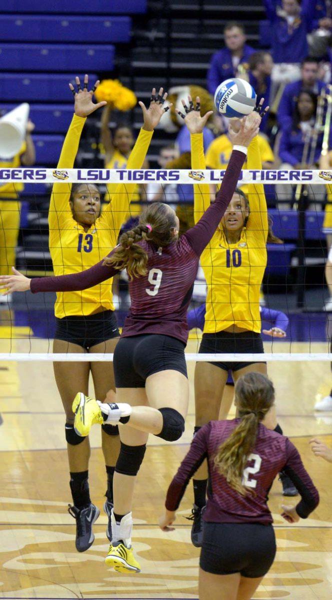 LSU sophmore middle blocker Briana Holman (13) and freshman outside hitter Mimi Eugene (10) defend the ball against Mississippi freshman middle blocker Laticia Valente (9) where LSU won 3-0 in the PMAC Wednesday.