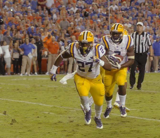 LSU freshman running back Leonard Fournette (7) carries the ball with sophomore defensive back Brandon Surtain (27) leading the way Saturday, October 11, 2014 during the Tigers' 30-27 victory in Ben Hill Griffin Stadium.