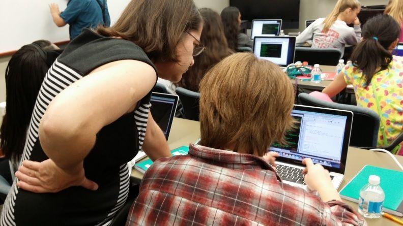 LSU associate professor of physics and CCT faculty member Juana Moreno assists Maya Cook, 13, of Baton Rouge, at a Computing and Math Saturdays session.&#160;