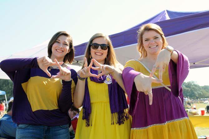 Women hold up their sorority symbols while tailgating Saturday, October 25, 2014.