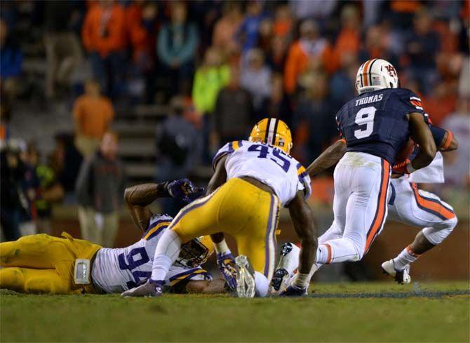 Auburn freshman running back Roc Thomas (9) runs the ball past LSU junior linebacker Deion Jones (45) and junior defensive lineman Danielle Hunter (94) Saturday, October 4, 2014 during the LSU Tigers' 41-7 loss against the Auburn Tigers in Jordan-Hare Stadium.