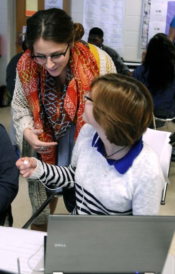 English secondary education senior Gabrielle Swindle explains an assignment to high school junior Isabella Frank during a group exercise Wednesday October 22, 2014 at McKinley high school.