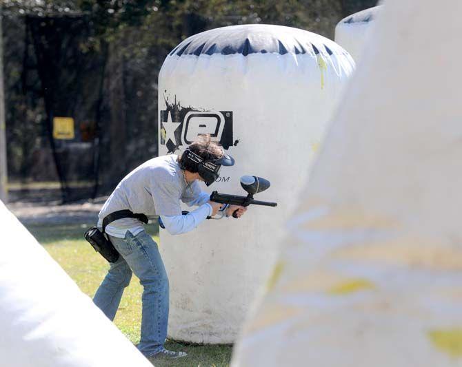 Team member of LSU's Tiger Paintball hides behind an inflatable in a round of speedball.