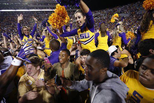 LSU cheerleaders celebrate amongst fans who swarmed the field after LSU's 10-7 victory over Mississippi in an NCAA college football game in Baton Rouge, La., Saturday, Oct. 25, 2014. (AP Photo/Jonathan Bachman)