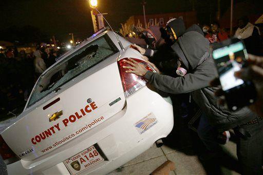 A group of protesters vandalize a police vehicle after the announcement of the grand jury decision not to indict police officer Darren Wilson in the fatal shooting of Michael Brown, an unarmed black 18-year-old, Monday, Nov. 24, 2014, in Ferguson, Mo. (AP Photo/David Goldman)