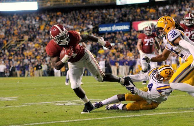 LSU junior cornerback Jalen Collins (32) and junior linebacker Kwon Alexander (4) attempt to tackle Alabama junior running back T.J. Yeldon (4) Saturday, November 8, 2014 during the Tigers' 20-13 loss against the Crimson Tide in Tiger Stadium.