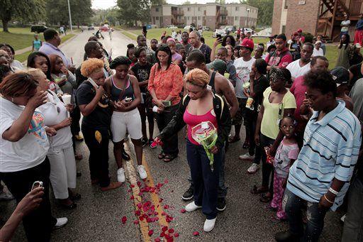 FILE- In this Aug. 9, 2014, file photo, Lesley McSpadden, center, drops rose petals on the blood stains from her 18-year-old son Michael Brown who was shot and killed a police officer in Ferguson, Mo., Aug. 9. With a grand jury&#8217;s decision this week not to indict police officer, Darren Wilson for Brown&#8217;s killing, prosecutors released thousands of pages of testimony, interviews and documents that shine new and often harsh light on the events that unfolded in this suburb&#8217;s darkest hours. (AP Photo/St. Louis Post-Dispatch, Huy Mach, File)