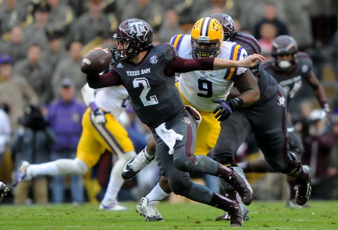 LSU junior defensive tackle Ego Ferguson (9) puts pressure on Texas A&amp;M sophomore quarterback Johnny Manziel (2) on Saturday, Nov. 23, 2013 during LSU's 34-10 victory against the Aggies in Tiger Stadium.