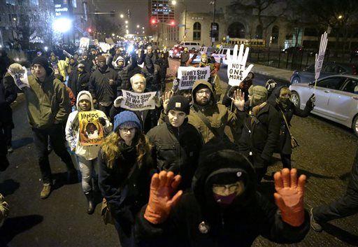 Protesters march during a rally near the Chicago Police headquarters after the announcement of the grand jury decision not to indict Ferguson police officer Darren Wilson in the fatal shooting of Michael Brown, an unarmed black 18-year old, Monday, Nov. 24, 2014, in Chicago. (AP Photo/Charles Rex Arbogast)