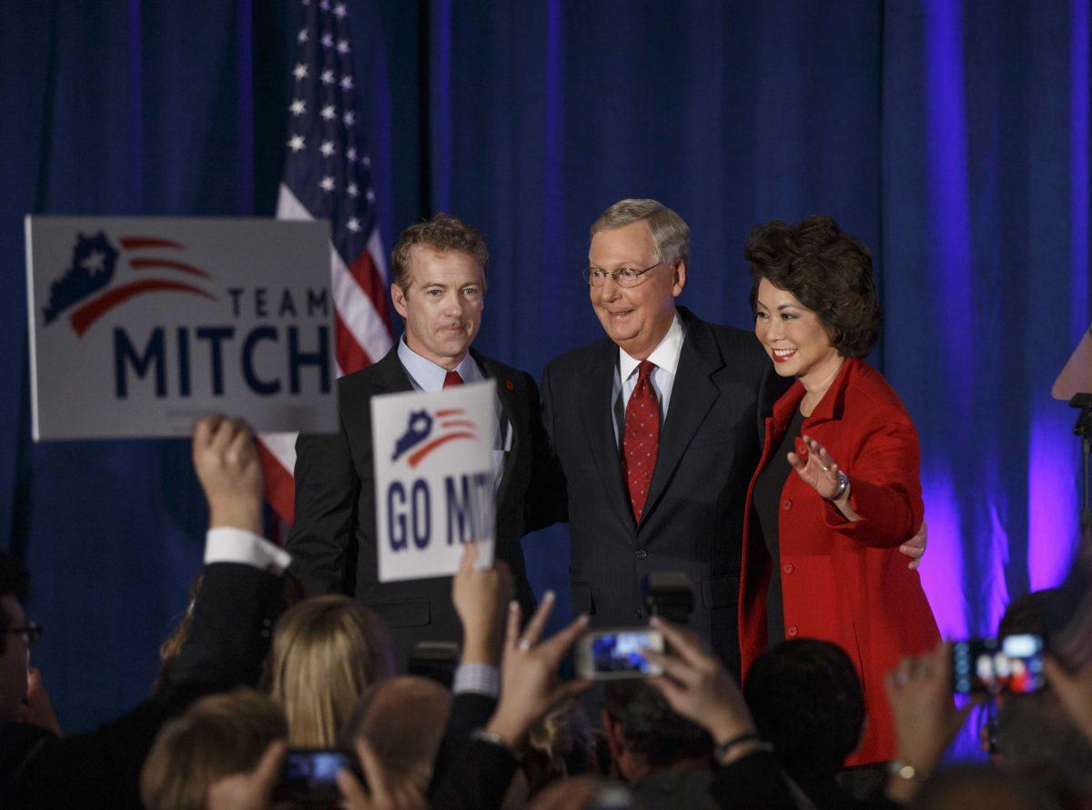 Senate Minority Leader Mitch McConnell, R-Ky., center, celebrates with Sen. Rand Paul, R-Ky., left, and his wife, former Labor Secretary Elaine Chao, at an election night party in Louisville, Ky.,Tuesday, Nov. 4, 2014. McConnell won a sixth term in Washington, with his eyes on the larger prize of GOP control of the Senate. The Kentucky Senate race, with McConnell, a 30-year incumbent fighting off a spirited challenge from Democrat Alison Lundergan Grimes, has been among the most combative and closely watched contests that could determine the balance of power in Congress. (AP Photo/J. Scott Applewhite)