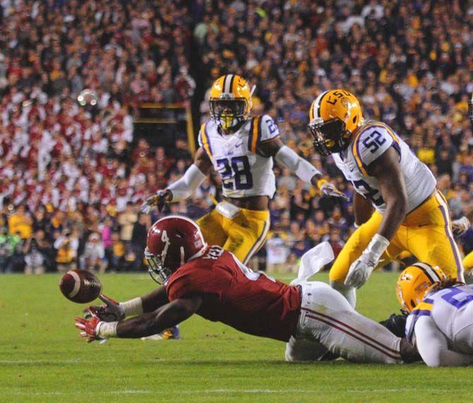 LSU junior defensive back Jalen Mills (28) and sophomore linebacker Kendell Beckwith (52) watch as junior linebacker Lamar Louis (23) forces Alabama junior running back T.J. Yeldon (4) to fumble the ball Saturday, November 8, 2014 during the Tigers' 20-13 loss against the Crimson Tide in Tiger Stadium.