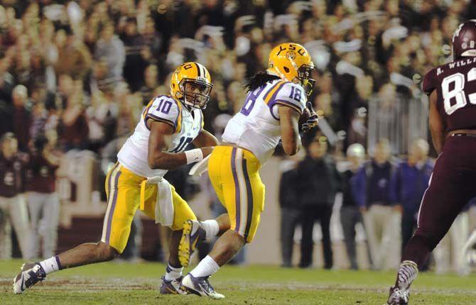 LSU sophomore quaterback Anthony Jennings (10) gives the ball to senior running back Terrence Magee (18) during the Tigers' 23-17 victory on Thursday, Nov.27, 2014 in Kyle field.