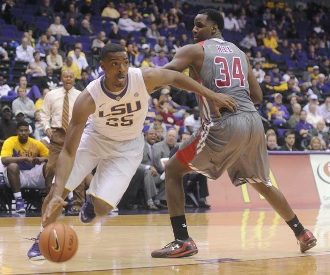 LSU sophomore forward Jordan Mickey (25) dribbles past defending junior forward Jerome Hill (34) during Tigers' 93-82 victory over Gardner-Webb on Saturday, Nov. 15, 2014 in the PMAC