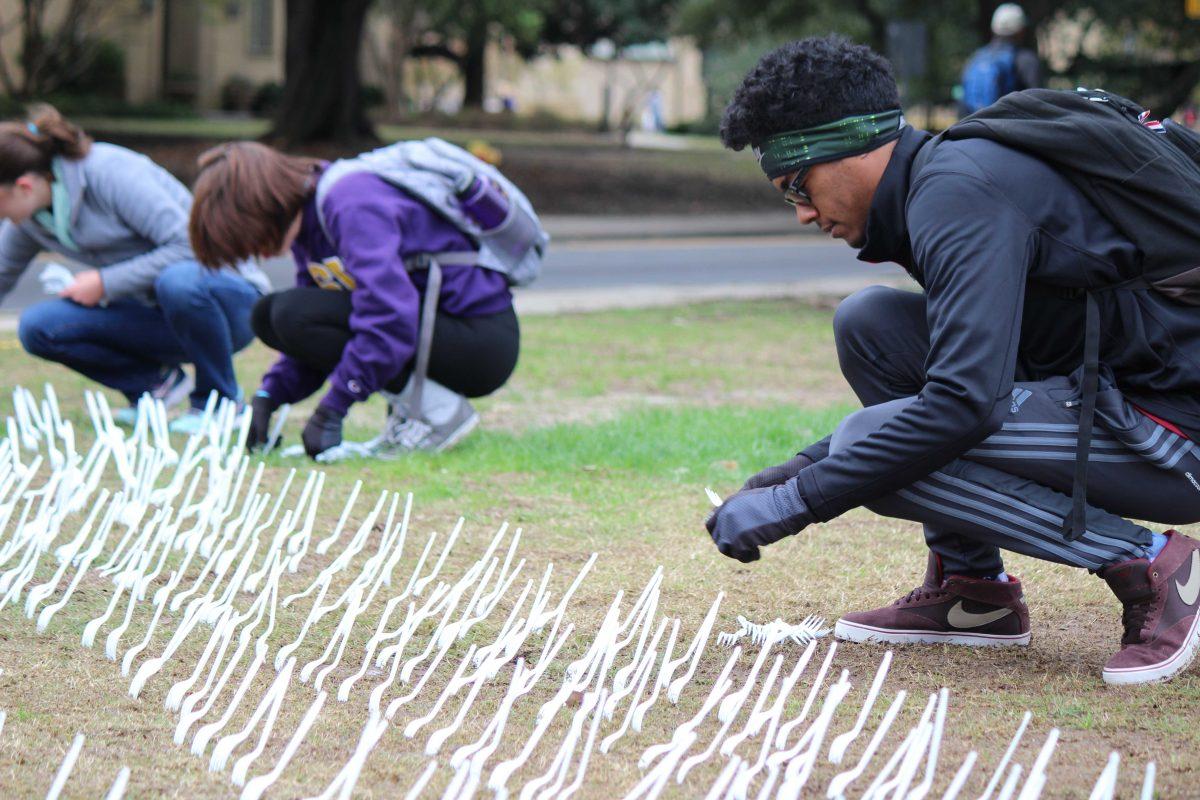 LSU Sophomore Austin Adams from Lafayette and other student-volunteers plant forks in the parade grounds to bring awareness to the homelessness problem in Louisiana.