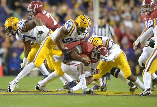 LSU junior defensive end Danielle Hunter (94) and junior linebacker Kwon Alexander (4) bring down Alabama senior quarterback Blake Sims (6) during the Tigers' matchup against the Crimson Tide in Tiger Stadium. The Tide leads the Tigers 10-7 at halftime.