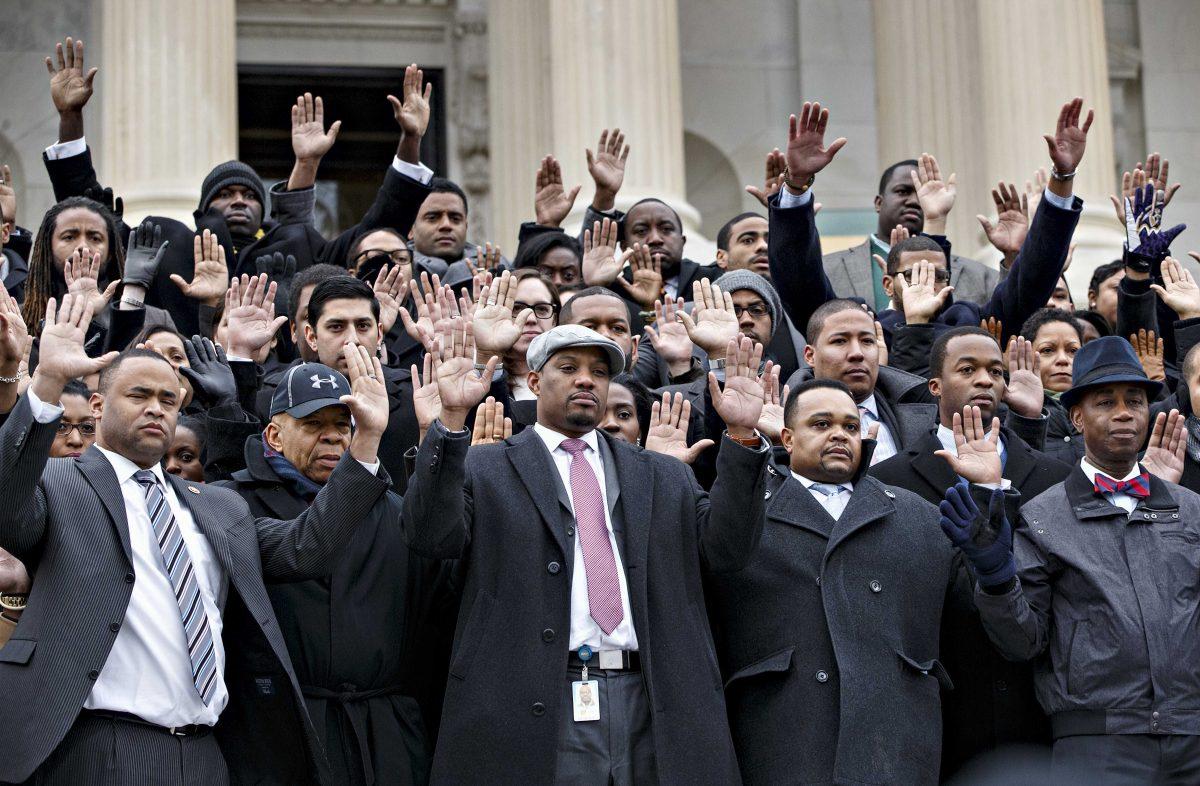 Congressional staff members gather on Capitol Hill in Washington, Thursday, Dec. 11, 2014, to raise awareness of the recent killings of black men by police officers, both of which did not result in grand jury indictments. They are joined by Rep. Elijah Cummings, D-Md., second from left. The walkout came as both houses of Congress attempt to pass a spending measure and avert government shutdown. (AP Photo/J. Scott Applewhite)