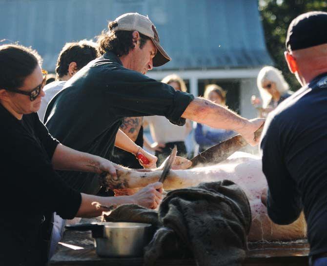 Toby Rodriguez and members of Lache Pas use knives to scrape hair off of a pig's skin Sunday, November 30, 2014 at La Boucherie Merci in Vermillionville, La.