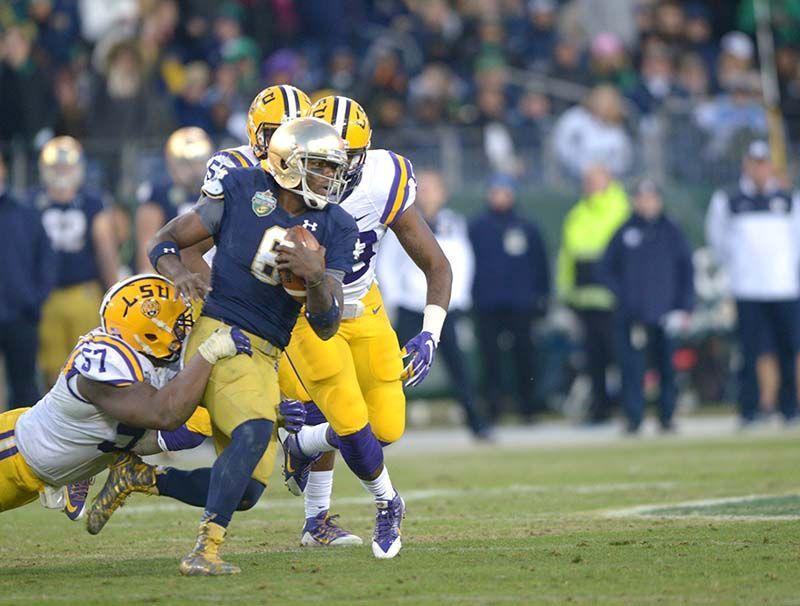 Notre Dame sophomore Malik Zaire (8) gets tackled by LSU freshman Davon Godchaux (57) in Notre Dame win 31-28 at Music City Bowl Tuesday, Dec. 30, 2014 at LP Field in Nashville.