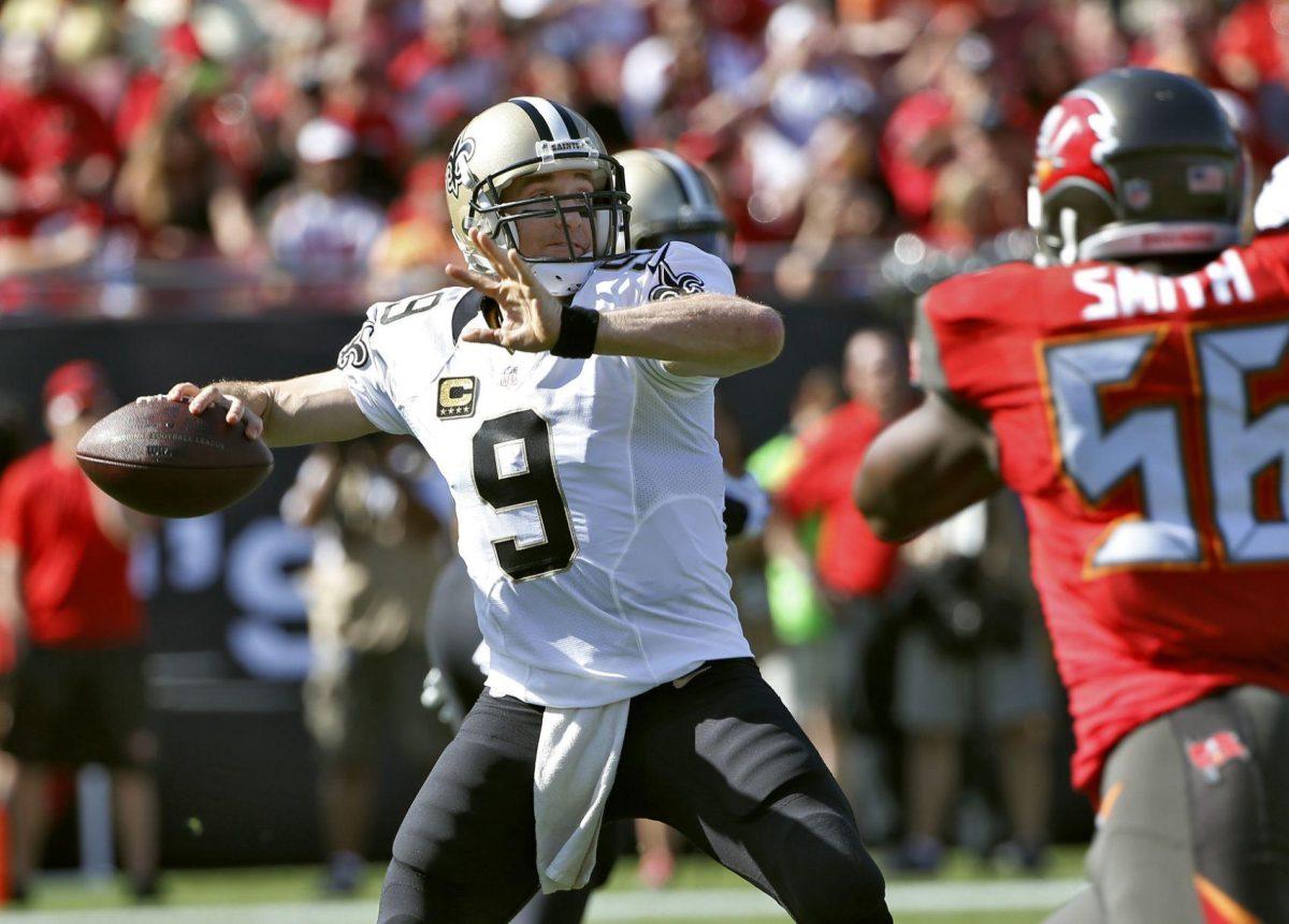 New Orleans Saints quarterback Drew Brees (9) throws a pass as he is pressured by Tampa Bay Buccaneers defensive end Jacquies Smith (56) during the first quarter of an NFL football game Sunday, Dec. 28, 2014, in Tampa, Fla. (AP Photo/Brian Blanco)