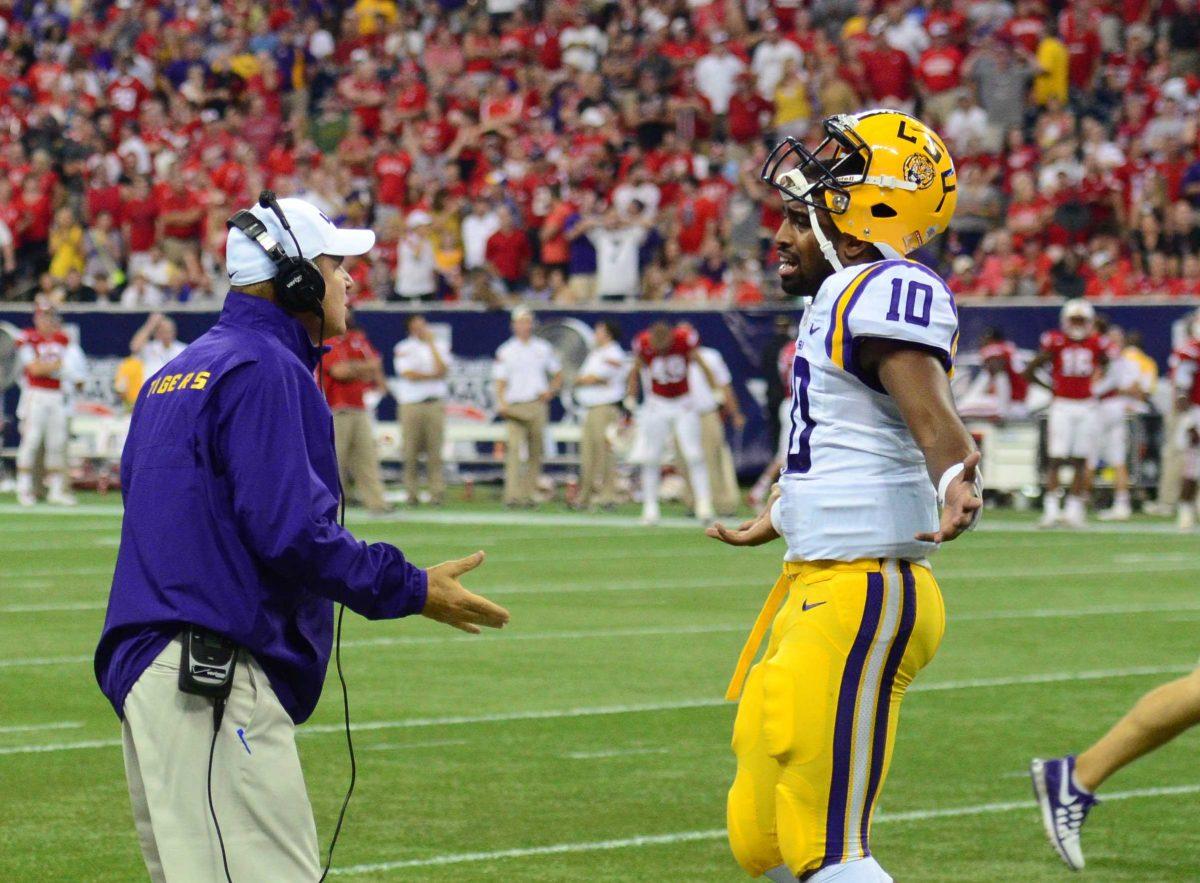 Head Coach Les Miles and Quarterback Anthony Jennings discus 2-point conversion during a timeout Saturday night August 30, 2014.