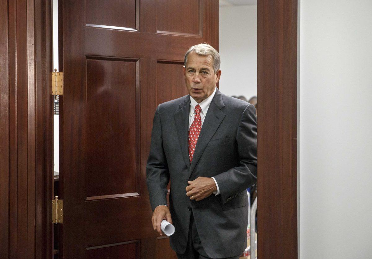 House Speaker John Boehner of Ohio emerges from a closed-door GOP caucus meeting on Capitol Hill in Washington, Wednesday, Dec. 10, 2014. With time running short before Congress adjourns, Republicans and Democrats agreed Tuesday on a $1.1 trillion spending bill to avoid a government shutdown and delay a politically-charged struggle over President Barack Obama's new immigration policy until the new year. (AP Photo/J. Scott Applewhite)