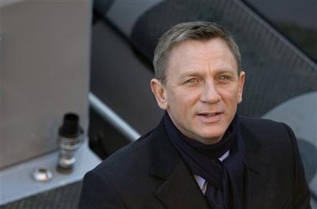 Actors Daniel Craig smiles for photographers as he films a scene for the new James Bond film, Spectre, in London, Tuesday, Dec. 16, 2014. (AP Photo/Alastair Grant)