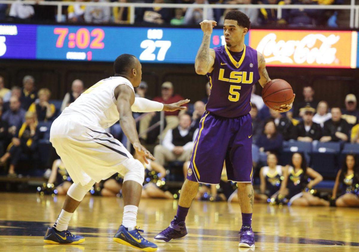 LSU guard Josh Gray (5) signals a play while being defended by West Virginia guard Jevon Carter (2) during an NCAA college basketball game, Thursday, Dec. 4, 2014, in Morgantown, W.Va. (AP Photo/Raymond Thompson)