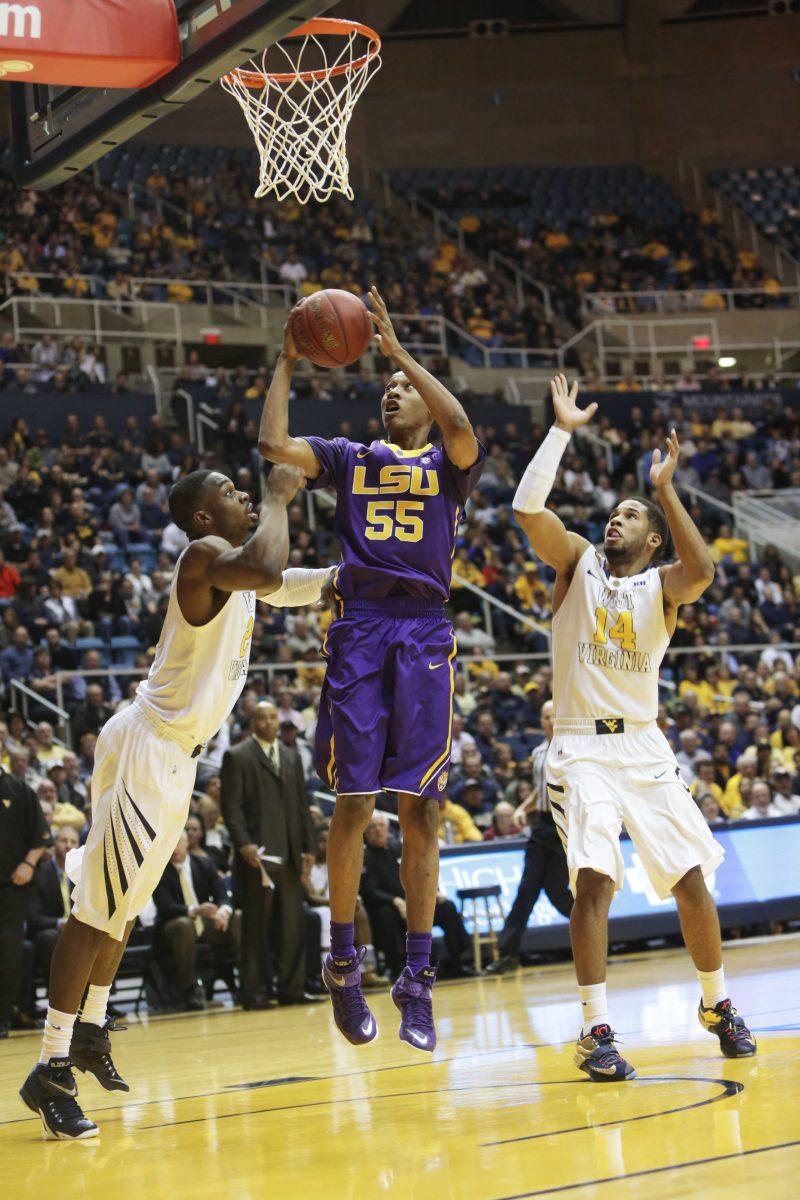 LSU guard Tim Quarterman (55) drives past West Virginia forward BillyDee Williams (21) and guard Gary Browne (14) during an NCAA college basketball game, Thursday, Dec. 4, 2014, in Morgantown, W.Va. (AP Photo/Raymond Thompson)