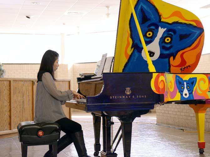 LSU student plays an original vintage Steinway piano painted by George Rodrigue. The George Rodrigue Foundation of the Arts donated this artwork to LSU School of Music.