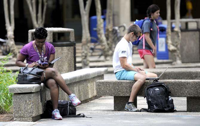 Students sit on a shaded bench between classes Monday, August 25, 2014 in the Quad.