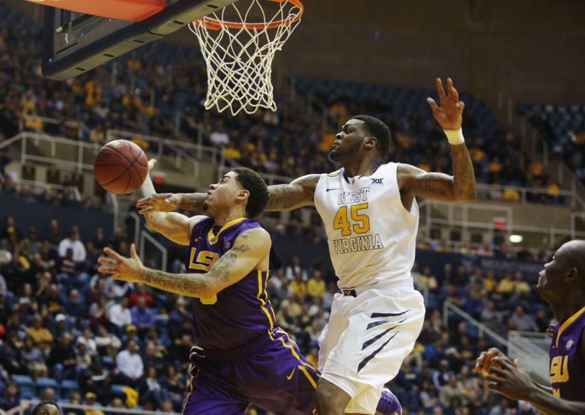 LSU guard Keith Homsby, left, is blocked by West Virginia forward Elijah Macon (45) during an NCAA college basketball game, Thursday, Dec. 4, 2014, in Morgantown, W.Va. (AP Photo/Raymond Thompson)