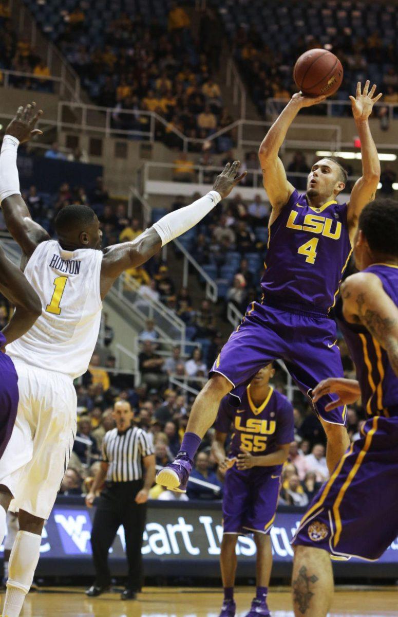 LSU guard Keith Homsby shoots over (4) West Virginia forward Jonathan Holton (1) during an NCAA college basketball game, Thursday, Dec. 4, 2014, in Morgantown, W.Va. (AP Photo/Raymond Thompson)