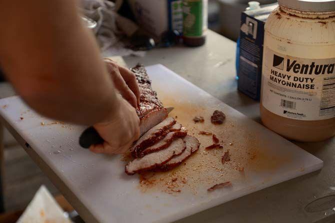 Barbecued pork loin is cut and sampled by the public Sunday, November 30, 2014 at La Boucherie Merci in Vermillionville, La.