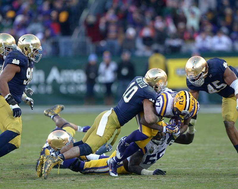 LSU senior running back Kenny Hilliard (27) gets tackled by Notre Dame sophomore starter Max Redfield (10) in a winning game for the Fighting Irish 31-28 Tuesday, Dec. 30, 2014 at LP Field in Nashville.