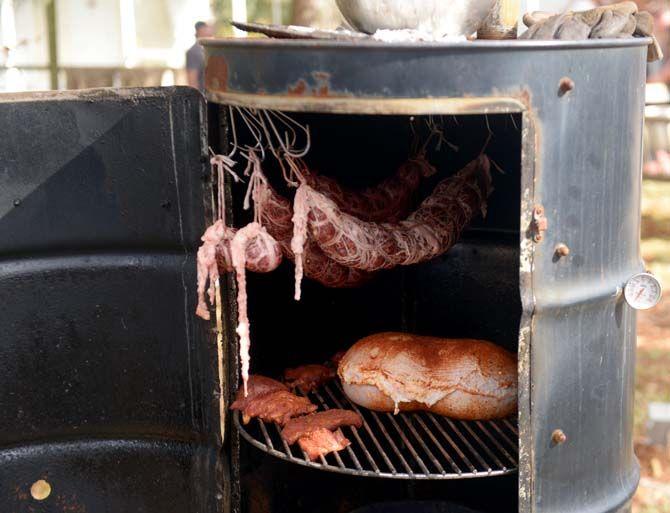 A smoker holds smoked caul fat, seasoned tasso and a stuffed stomach known as a "gog" Sunday, November 30, 2014 at La Boucherie Merci in Vermillionville, La.