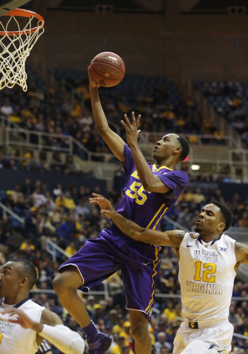 LSU guard Tim Quarterman (55) drives past West Virginia guard Tarik Phillip (12) during an NCAA college basketball game, Thursday, Dec. 4, 2014, in Morgantown, W.Va. (AP Photo/Raymond Thompson)