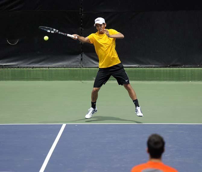 LSU sophomore Tam Trinh returns a serve Sunday, March 30, 2014 during the Men's Tennis doubles match against Florida at W.T. "Dub" Robinson Stadium.