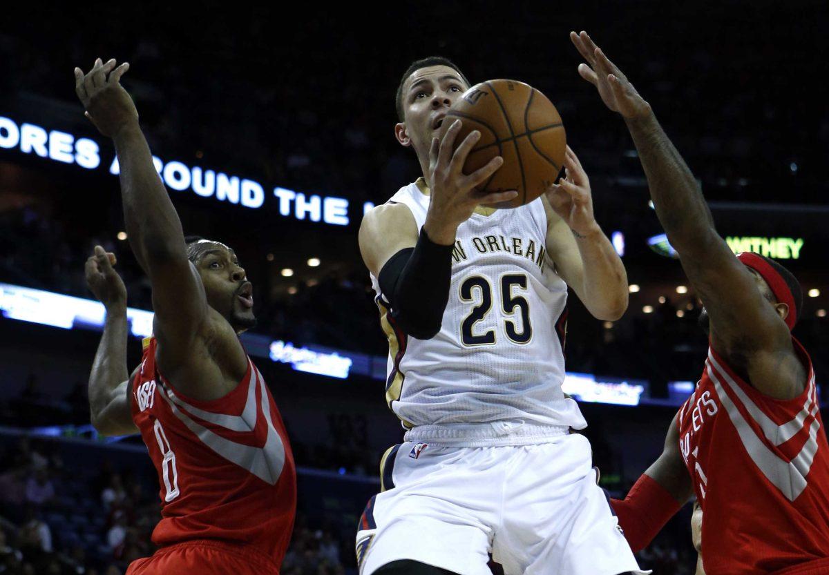 New Orleans Pelicans guard Austin Rivers (25) lays in a reverse layup around Houston Rockets forward Joey Dorsey (8) and forward Josh Smith (5) in the second half of an NBA basketball game Friday, Jan. 2, 2015, in New Orleans. (AP Photo/Butch Dill)