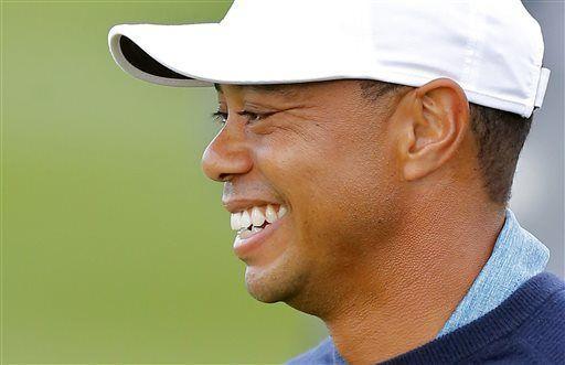 Tiger Woods smiles as he walks on the eighth hole during a practice round at the Phoenix Open golf tournament, Tuesday, Jan. 27, 2015, in Scottsdale, Ariz. (AP Photo/Rick Scuteri)