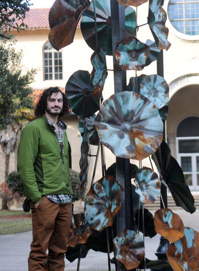 LSU alumnus Andre Charitat stands next to his sculpture, titled "Growth," on Saturday, Jan. 10, 2015, in front of Foster Hall.