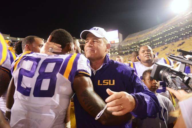 LSU football head coach Les Miles pulls in junior safety Jalen Mills (28) for a celebratory hug Saturday, September 6, 2014 after the Tigers' 56-0 win against Sam Houston State in Tiger Stadium.