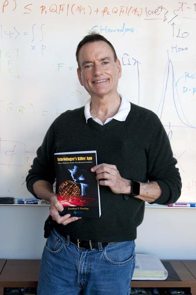 LSU physics Professor Dr. Jonathan Dowling stands with his book "Schrodinger's Killer App" that discusses the quantum computer.