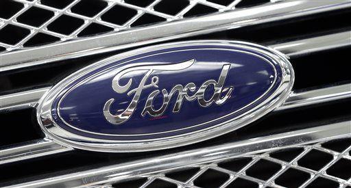 In this photo taken Monday, Jan. 5, 2015, the Ford logo shines on the front grille of a 2014 Ford F-150, on display at a local dealership in Hialeah, Fla. Ford's net income tumbled in the fourth quarter as the company took an expected charge to deal with currency devaluation at its Venezuelan operations, the company announced, Thursday, Jan. 29, 2015. But without that loss and other one-time items, Ford came out ahead of Wall Street's expectations for the fourth quarter and the full year. (AP Photo/Alan Diaz)