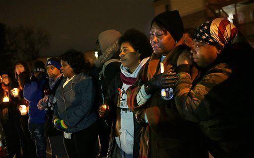 Desuirea Harris, the grandmother of Mike Brown, second from right, is comforted by Lala Moore, right, at the memorial to Brown in the Canfield Green Apartments, in St. Louis, marking six months since Brown was shot by Ferguson police officer Darren Wilson on Monday, Feb. 9, 2015. (AP Photo/St. Louis Post-Dispatch, Robert Cohen) EDWARDSVILLE INTELLIGENCER OUT; THE ALTON TELEGRAPH OUT