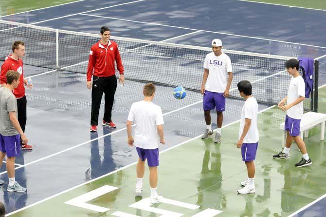 Members of both LSU and Wisconsin's tennis teams pass a soccer ball while waiting for the courts to dry on Sunday, Feb. 1, 2015, at W.T. "Dub" Robinson Stadium.