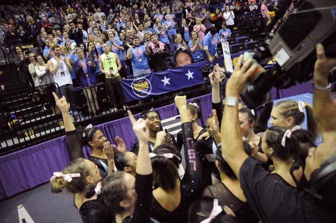 LSU gymnastics team celebrates in front of a lively crowd of 7,722 during the Tigers' 198.075-196.850 victory against No. 9 Georgia on Friday, Feb. 6, 2015. in the PMAC.