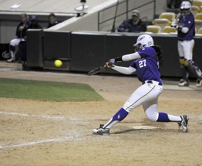 LSU sophomore infielder and pitcher Bianka Bell (27) slams a hit Friday, Feb. 28, 2014 during the Lady Tigers' 8-0 victory against the Lady Harvard Crimson during day one of the Gold and Purple Challenge at Tiger Park.