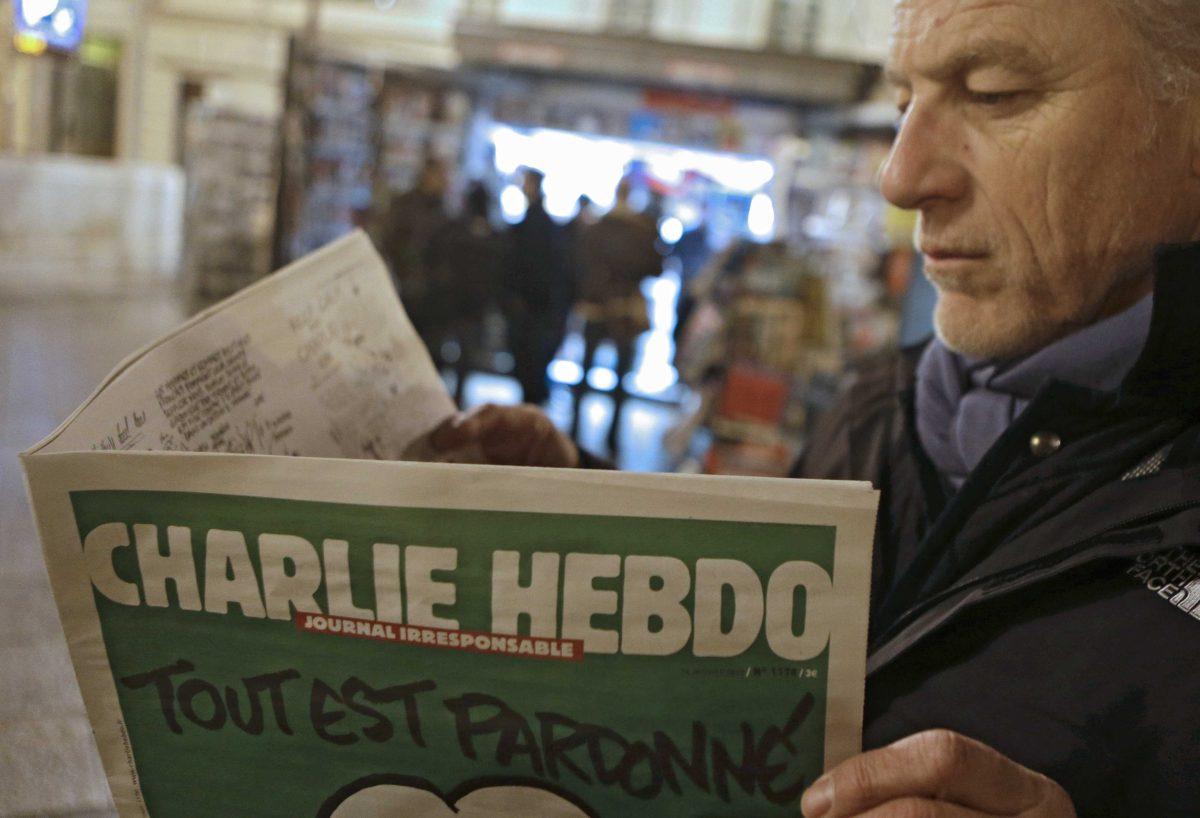 File - In this Wednesday, Jan. 14, 2015 file photo, Jean Paul Bierlein reads the latest issue of Charlie Hebdo outside a newsstand in Nice, southeastern France. When cartoonists at a French publication that had poked fun at the Prophet Muhammad were shot dead, millions around the world felt it as an attack on freedom of speech. Since the rampage, French authorities have arrested dozens of people _ including a comedian _ for appearing to praise the terrorists or encourage more attacks. (AP Photo/Lionel Cironneau, File)