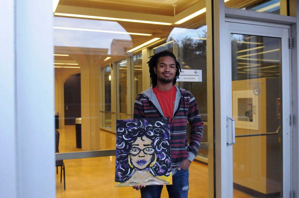 Digital art senior and president of the Black Artists Initiative organization, Nicholas Belson, holding an artwork on Feb. 21, 2015, by Sophomore kinesiology major Atashia Hill. As a part of "Black Girls Rock!" a multifaceted art show, this will be shown along with many others works this Thursday, Feb. 26, 2014 in the Cotillion Ballroom at 7 o'clock P.M.